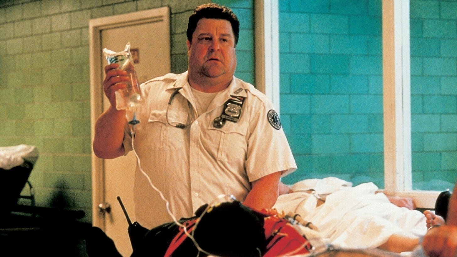 John Goodman holds up an IV bag in "Bringing Out the Dead" (1999)