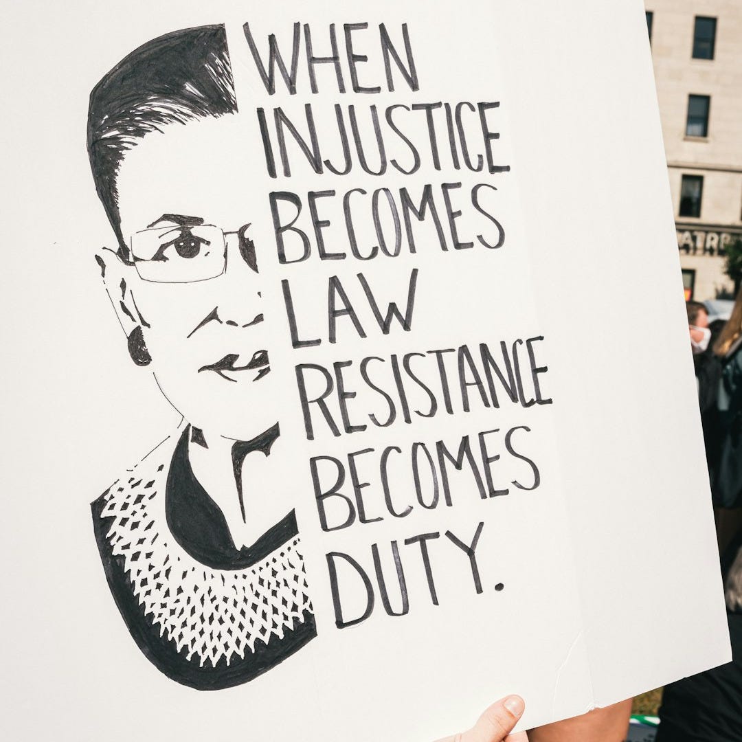 a person holding a sign that says when justice becomes law, resistance becomes duty