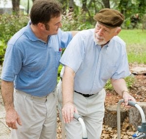 a young man walking with an older man using a walker