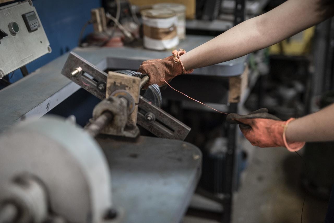 Person holding a power tool at a work bench, doing a task that clearly requires fine motor control Person holding a power tool at a work bench, doing a task that clearly requires fine motor control