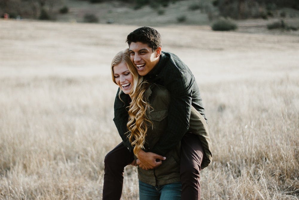 woman giving man piggyback ride woman giving man piggyback ride