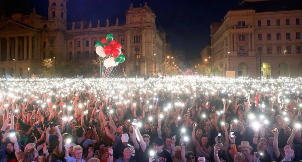 A group of people holding balloons and lights

Description automatically generated