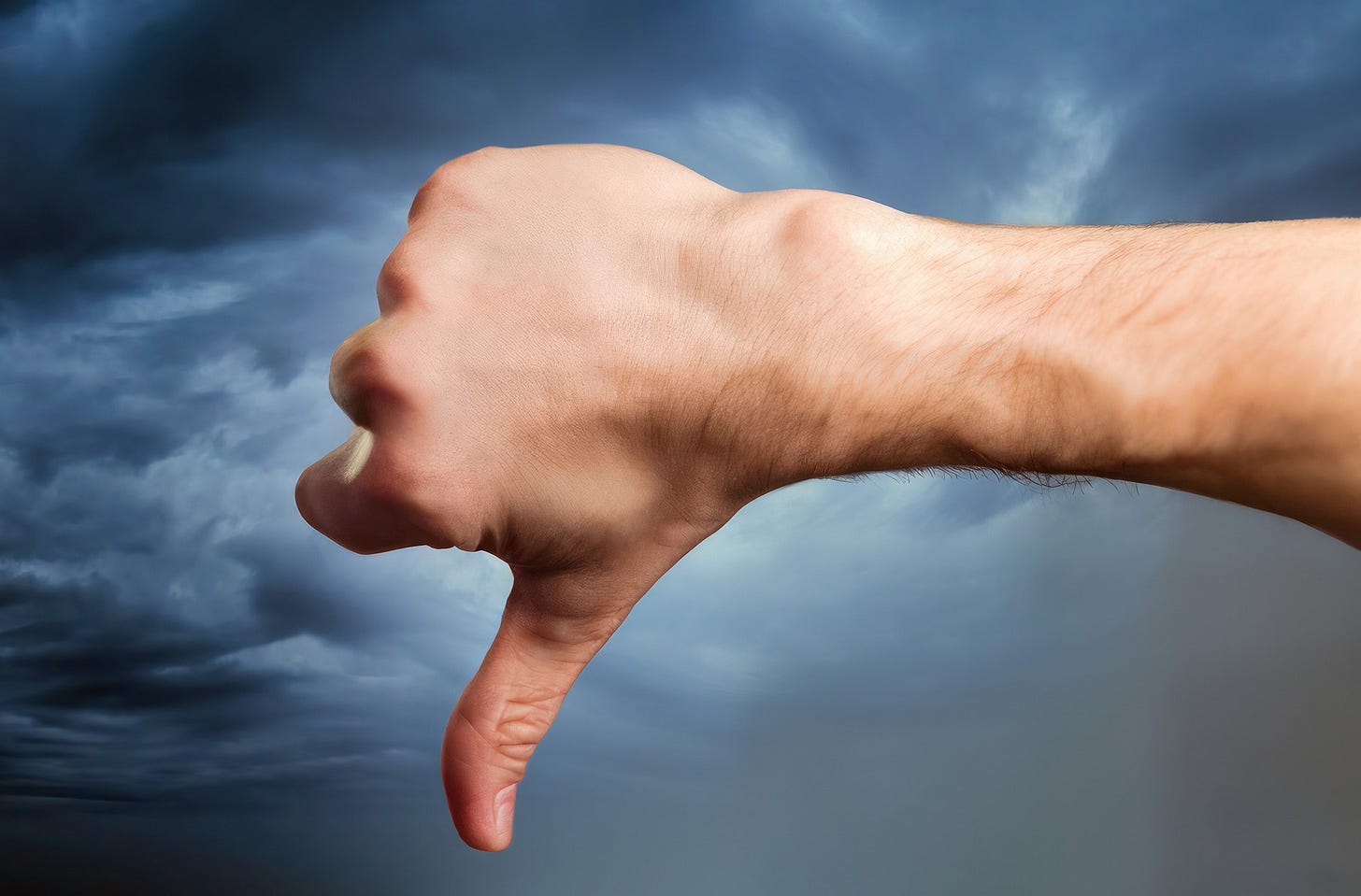 Uma mão com o polegar para baixo, indicando rejeição