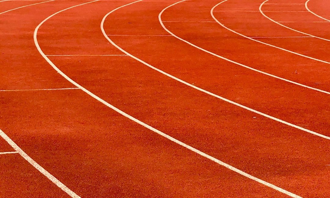 a red running track with white lines on it a red running track with white lines on it