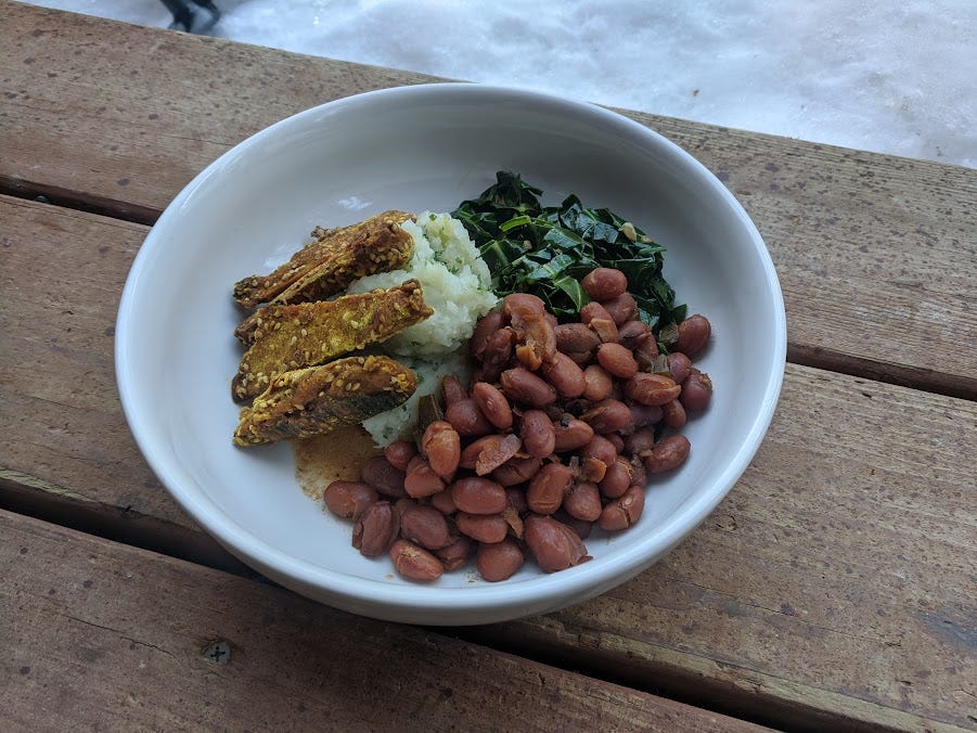 a bowl of beans, chickin', mashed potatoes and greens