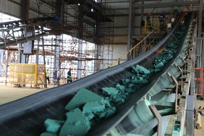 A conveyor belt carries chunks of raw cobalt. A conveyor belt carries chunks of raw cobalt.