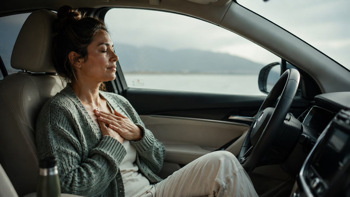 Woman sitting quietly in a parked car, taking a reflective pause in the middle of a busy day.