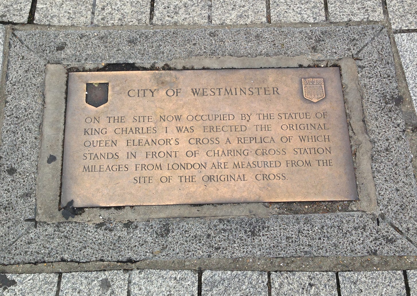 Photograph of a brass plaque set into paving stones, with an inscription describing how distances to London are measured to this spot, which was where the original Charing Cross once stood Photograph of a brass plaque set into paving stones, with an inscription describing how distances to London are measured to this spot, which was where the original Charing Cross once stood