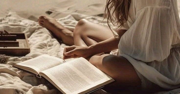 Chica en la playa sentada sobre una toalla leyendo un libro Chica en la playa sentada sobre una toalla leyendo un libro