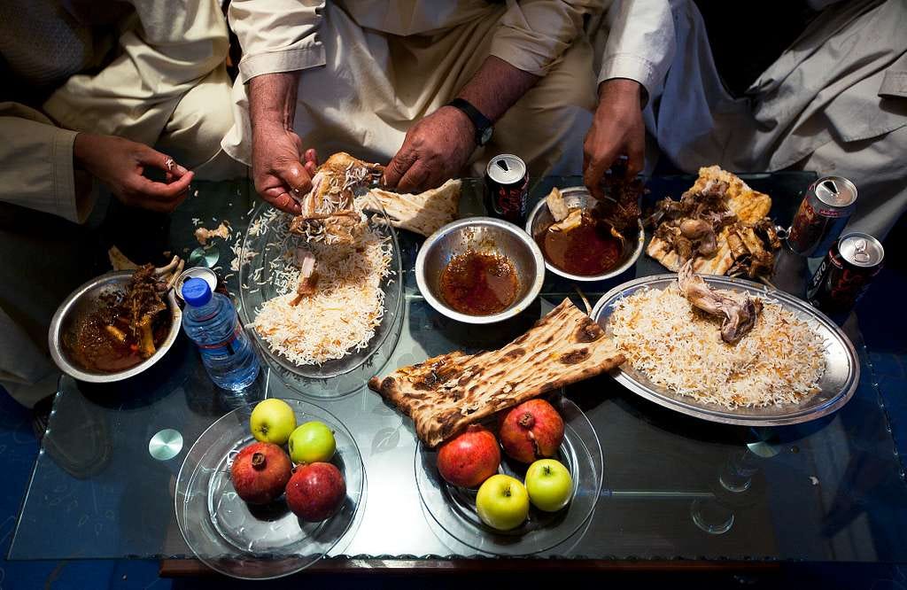Overhead image of Middle Eastern persons at the table having fellowship over a shared meal. Overhead image of Middle Eastern persons at the table having fellowship over a shared meal.