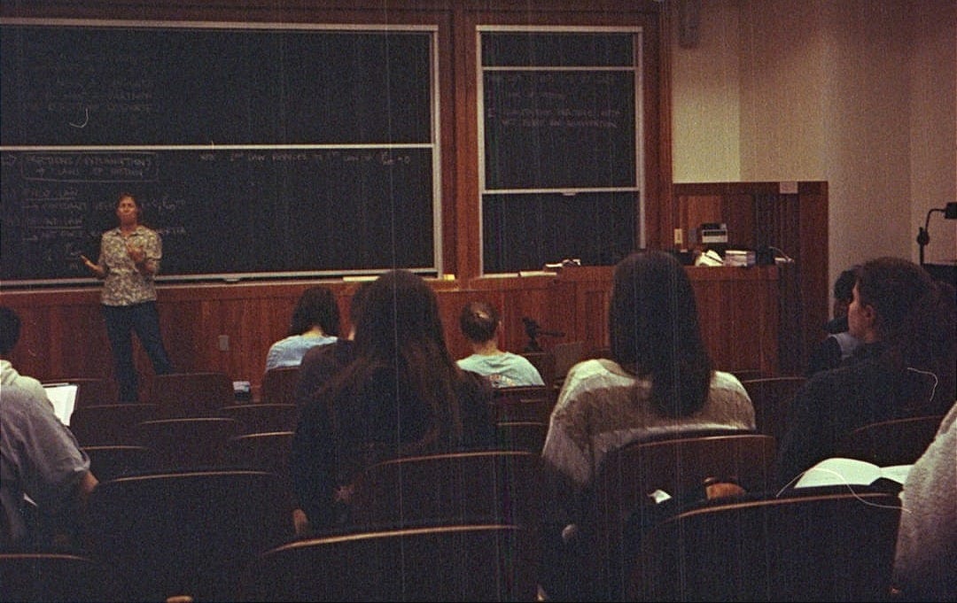 A group of people sitting in front of a blackboard