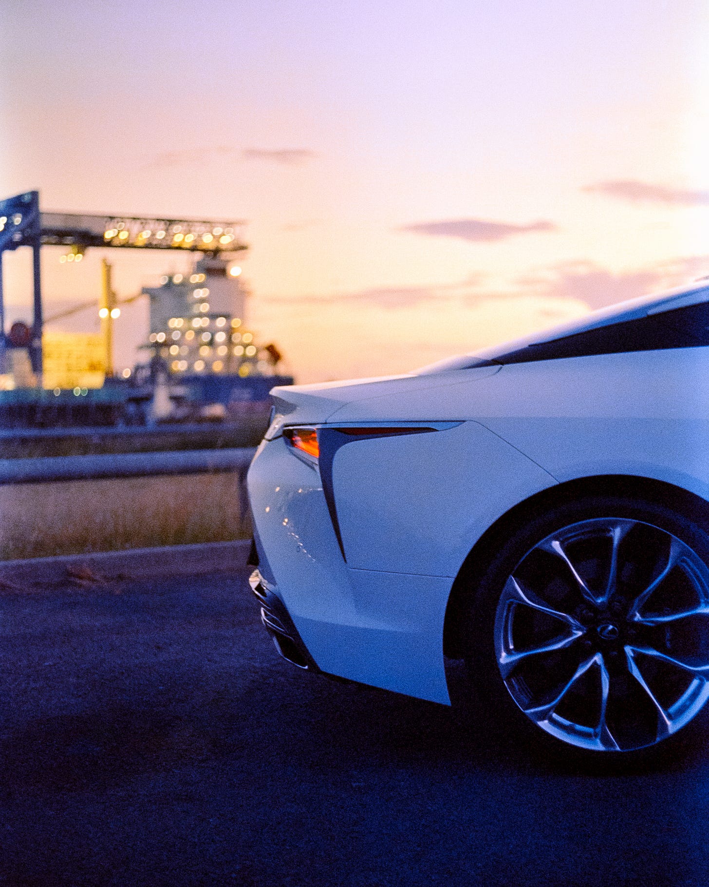 A close up of the rear wheel and tail light of the car as the last bit of sunlight lingers. A close up of the rear wheel and tail light of the car as the last bit of sunlight lingers.