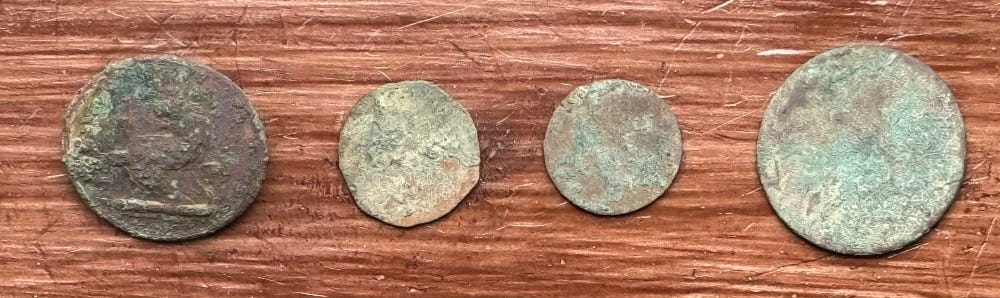four coin type objects sitting on some wood four coin type objects sitting on some wood