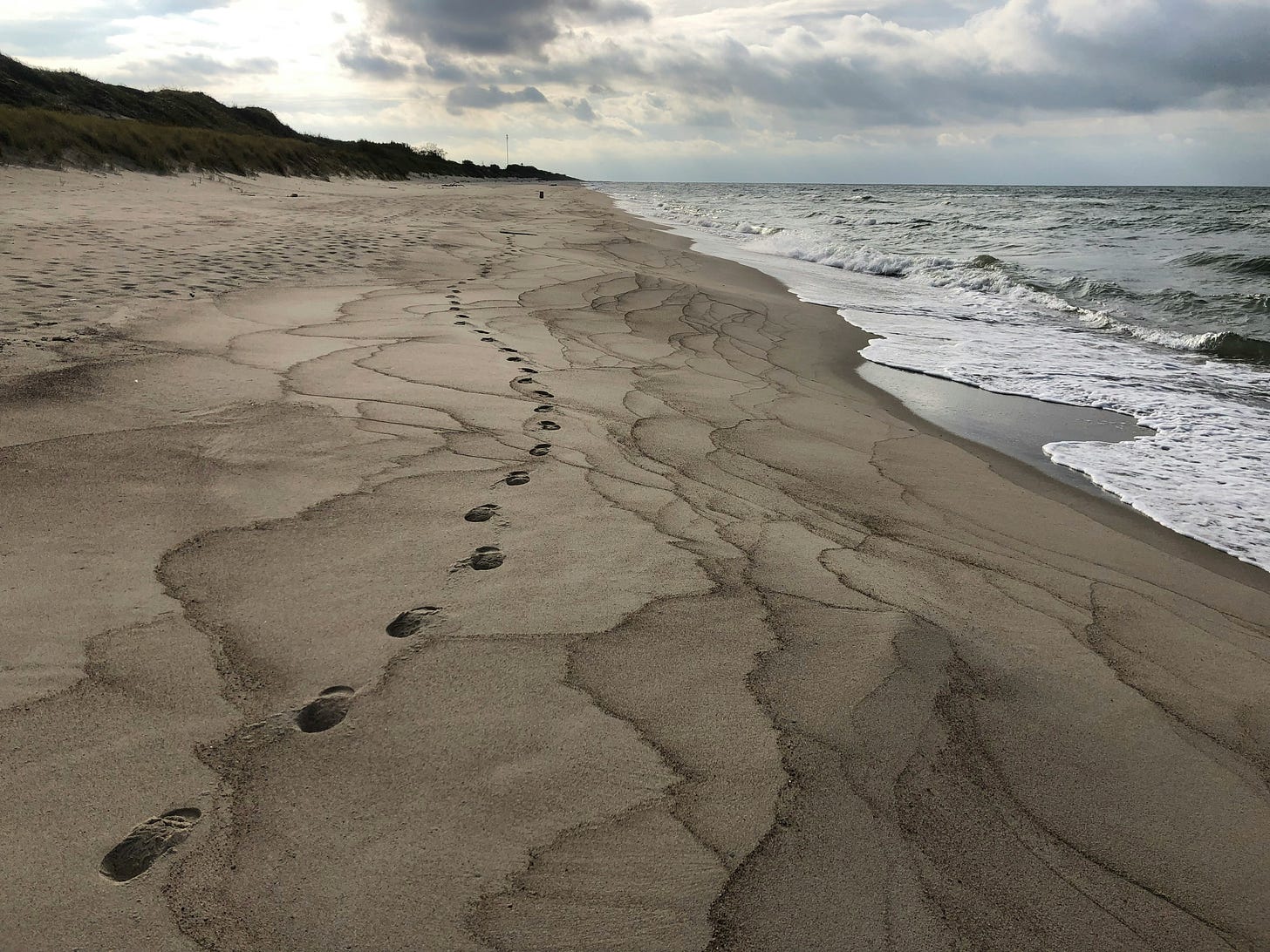 Footprints on the sand waves at the shore of the autumn Baltic sea. Cover image to BottBott's post I Created this Piece on Falling in Love with an LLM and It's Fucking Moving