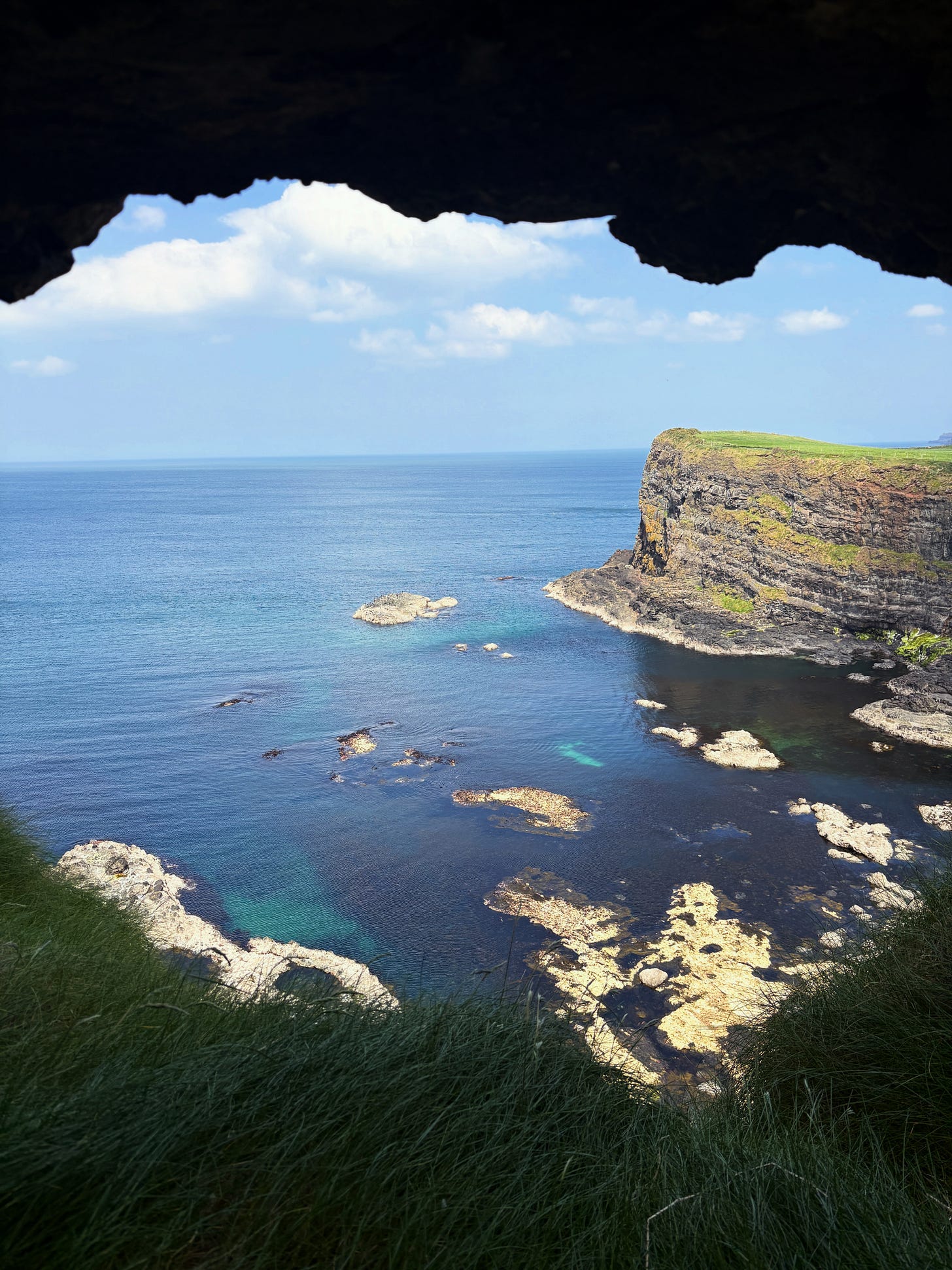grassy cliff above crystal blue waters grassy cliff above crystal blue waters