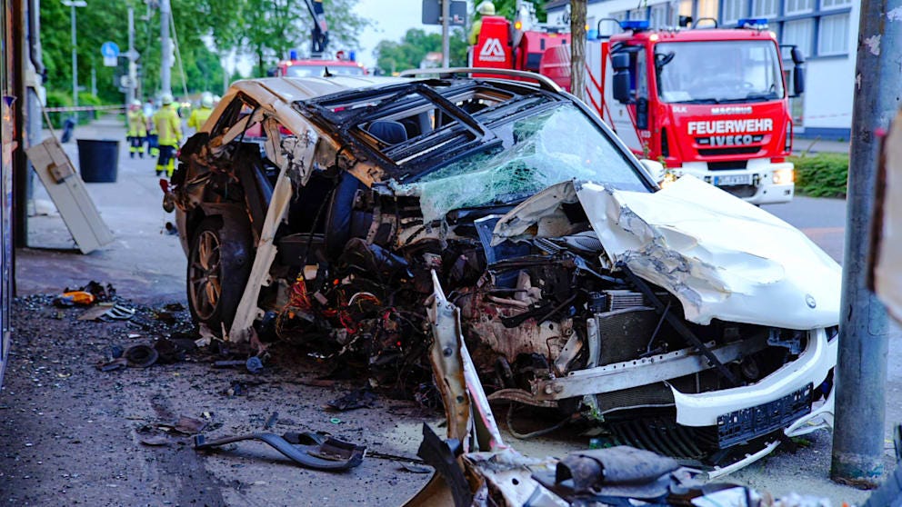 The white Mercedes GLK is destroyed on the roadside after the accident