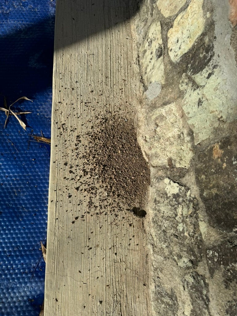 A pile of dirt and small stones next to a pool.