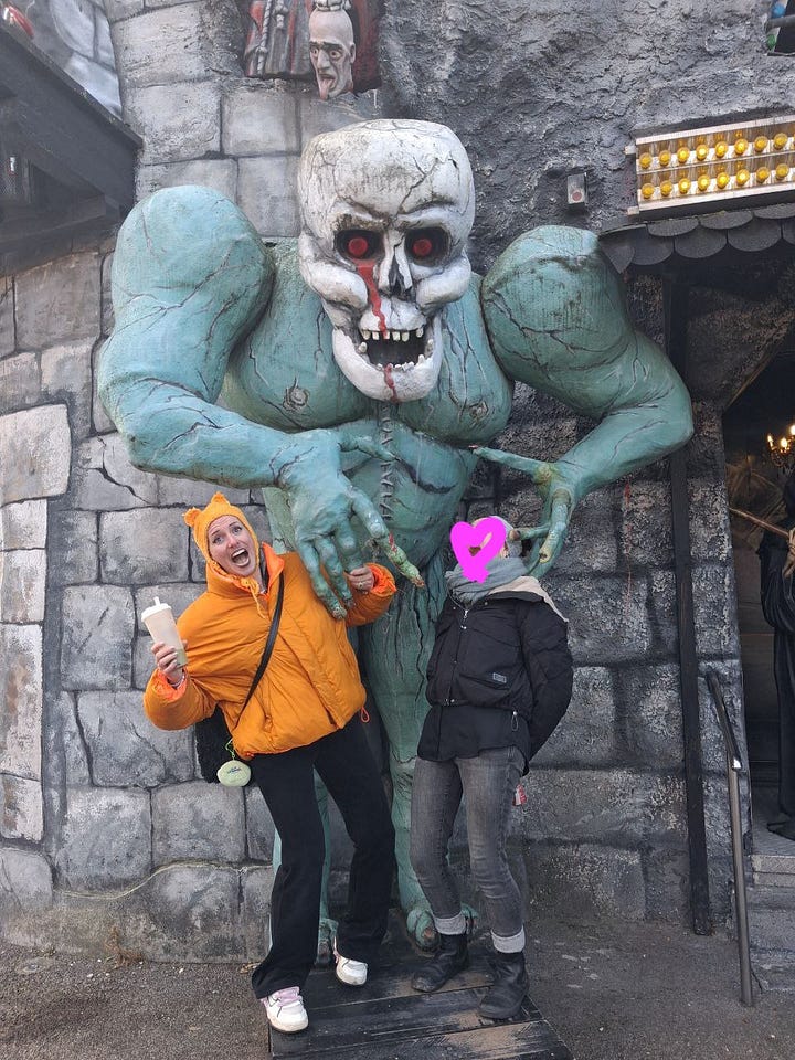 Me in a cafe with a cake in pink sweater, hiding behind pink flowers. And me and my friend standing in front of a giant zombie, pretending to scream.