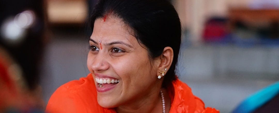 selective focus photography of smiling woman wearing red shirt