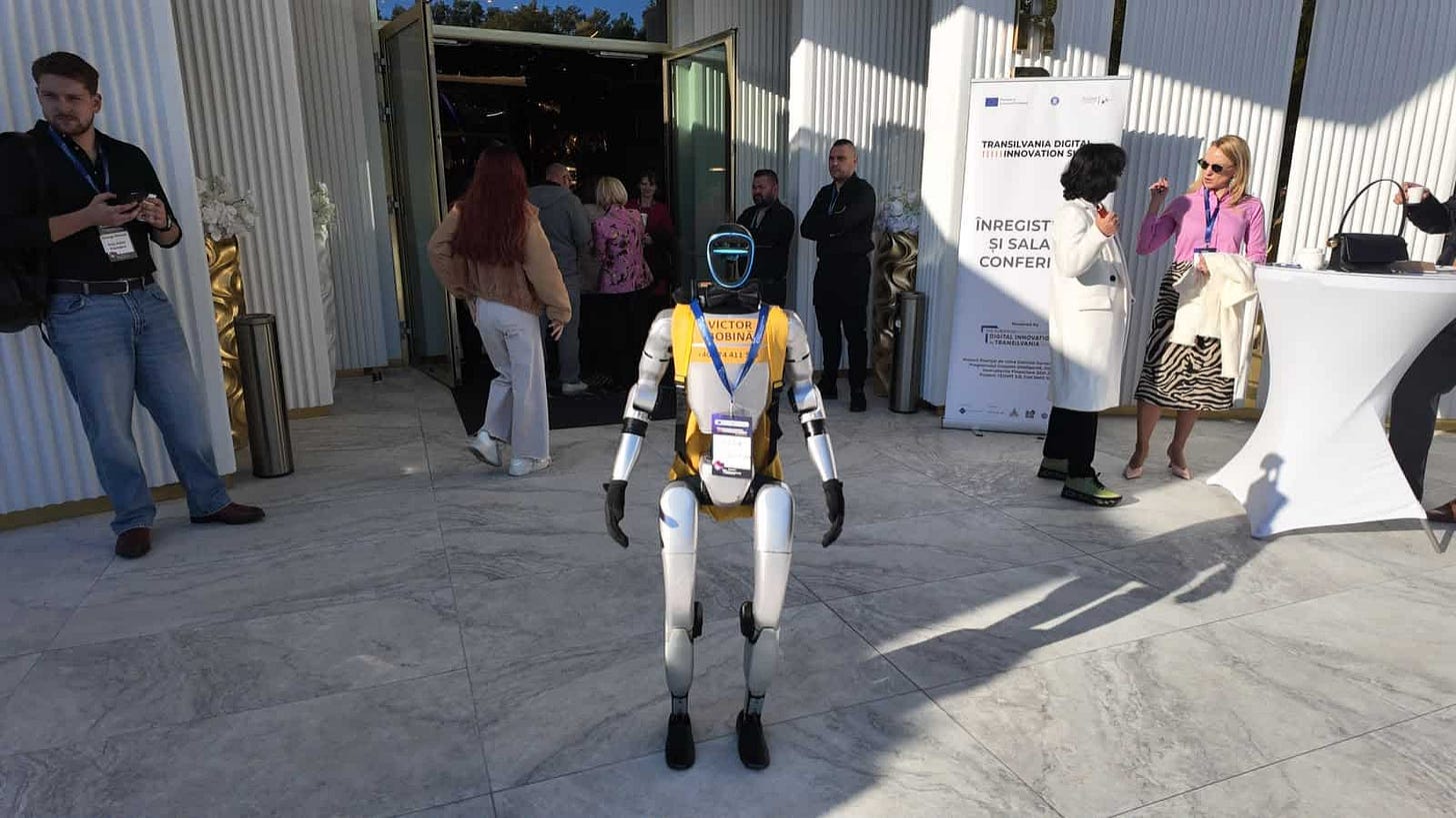 Robotul Victor Bobină, participant la eveniment, interacționează cu vizitatorii în fața unei clădiri moderne, în Cluj.