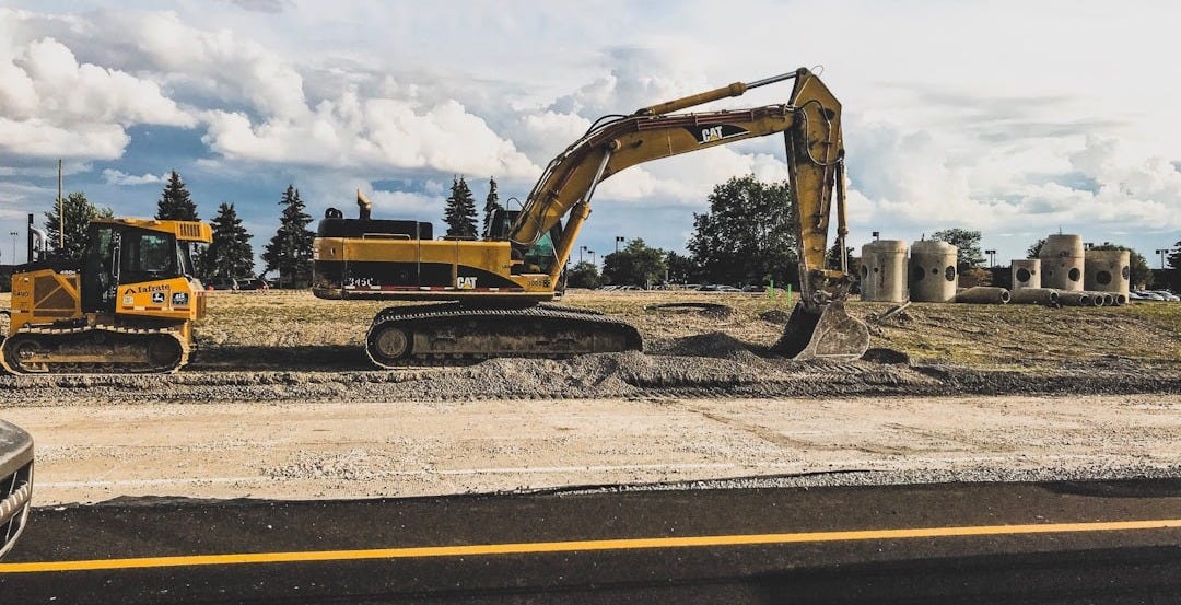 yellow Caterpillar excavator digging up dirt yellow Caterpillar excavator digging up dirt