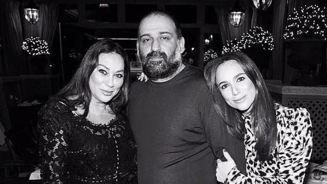 черно-белое фото бородатого мужчины с двумя женщинами, младшая обнимает его за плечи
