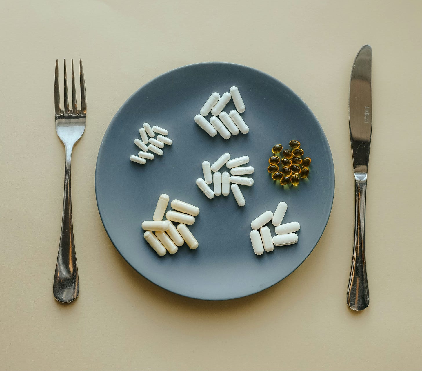 a pile of tablets on a plate with a knife and fork next to it