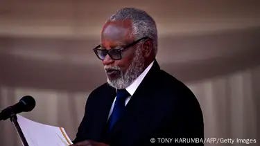 Nujoma wears glasses and a tie as he speaks into a microphone in this photo from 2019 Nujoma wears glasses and a tie as he speaks into a microphone in this photo from 2019