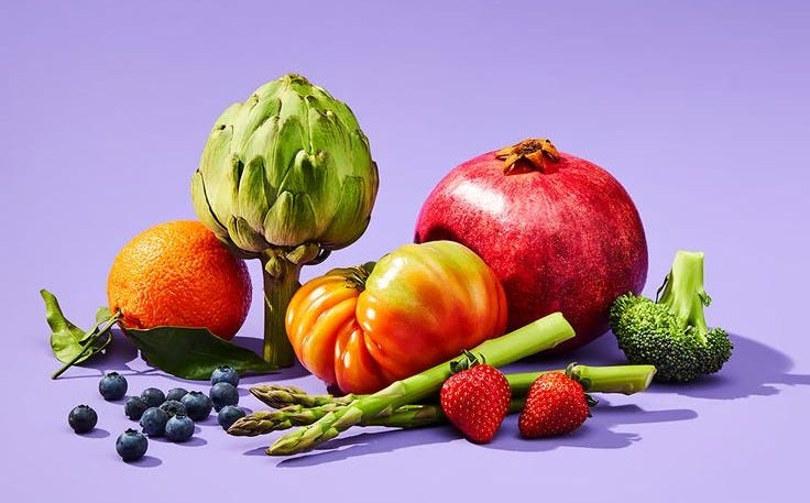 This may contain: an assortment of fruits and vegetables on a purple background