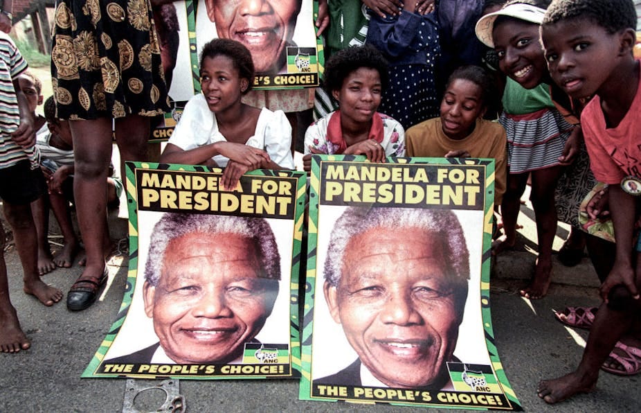Young people pose with posters saying 'Mandela for president'. Young people pose with posters saying 'Mandela for president'.