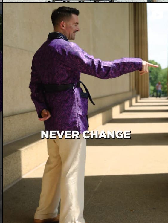 man in purple smoking jacket pointing