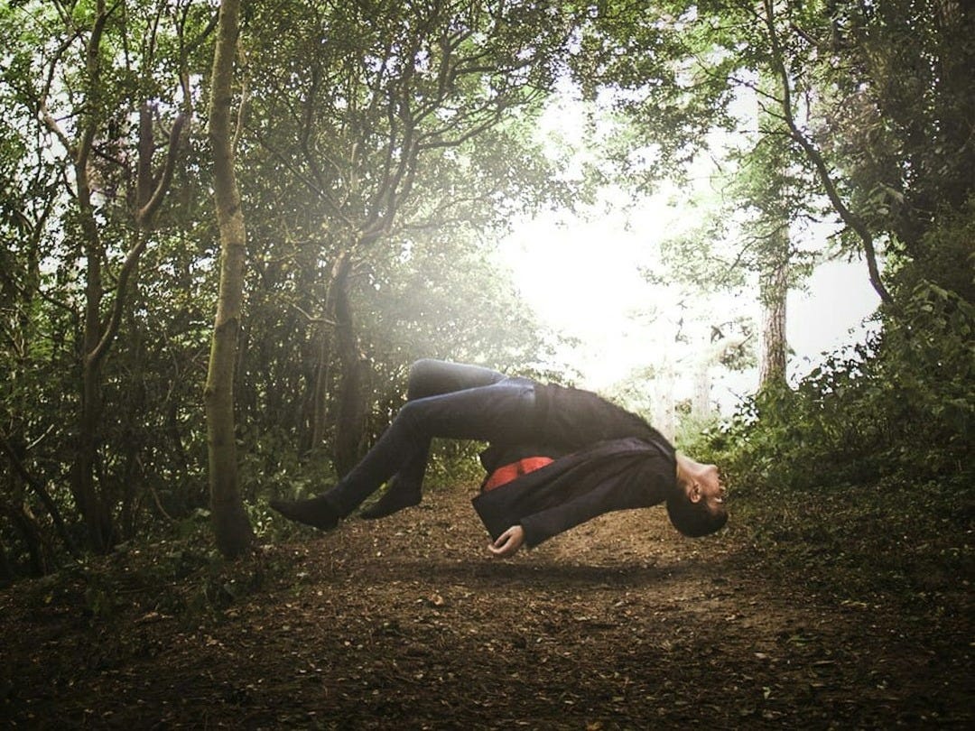 a man is doing a handstand in the woods a man is doing a handstand in the woods