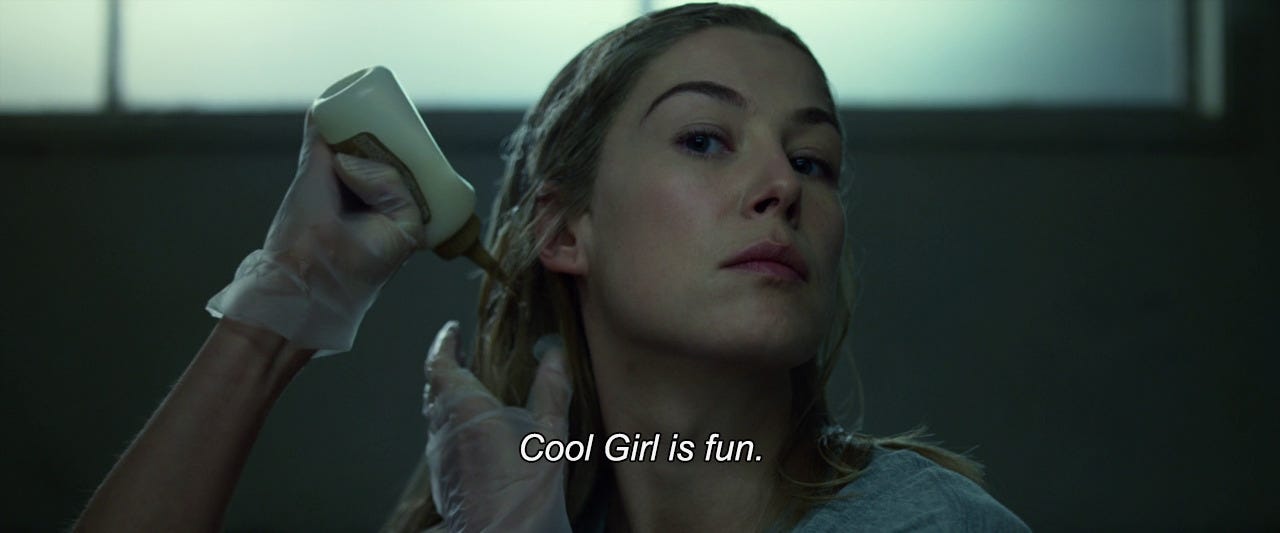 A film still from GONE GIRL. Rosamund Pike continues to dye her hair. The caption reads "Cool Girl is fun".