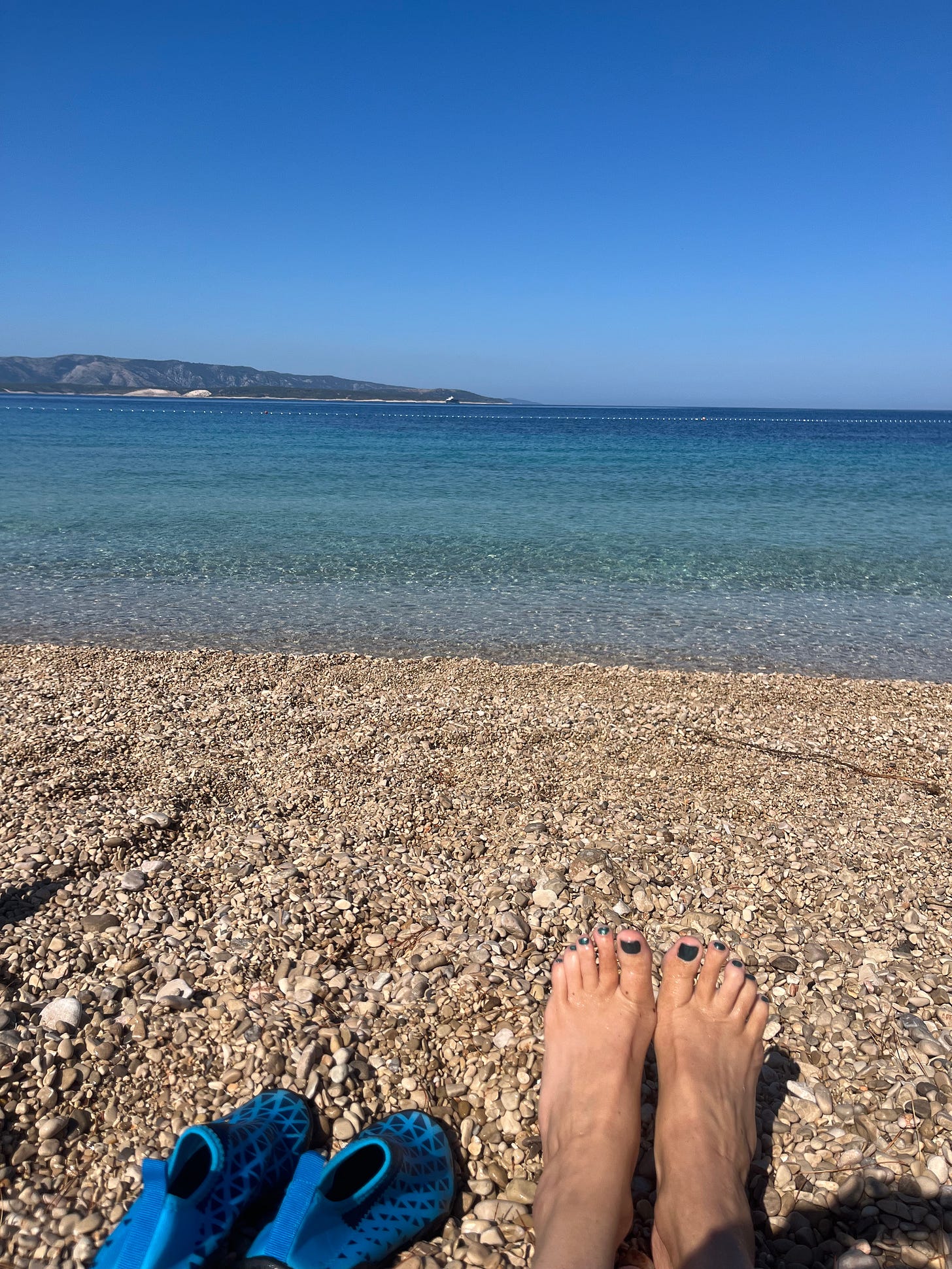 a woman's feet on a pebble beach