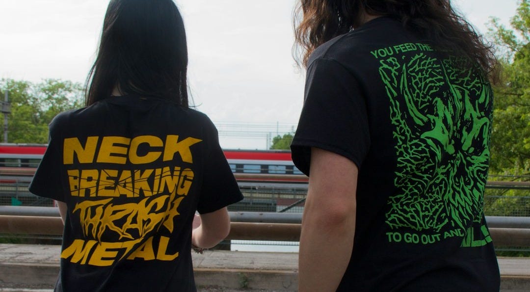 Two people wearing metal band t-shirts outdoors. Two people wearing metal band t-shirts outdoors.