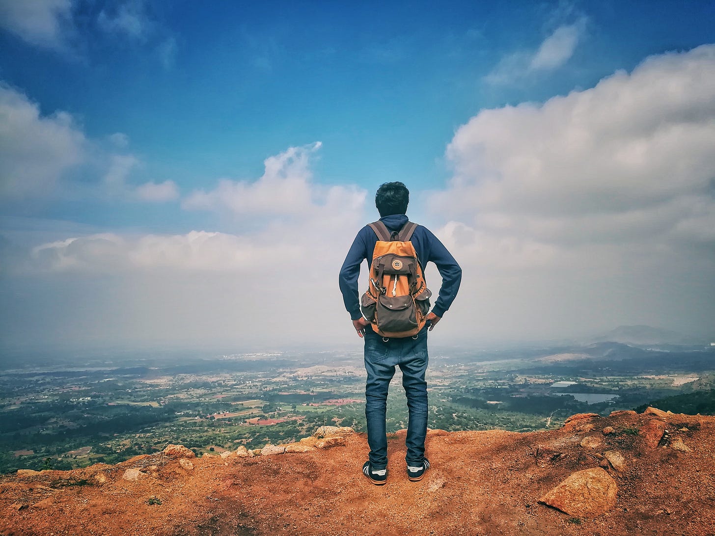A man standing on a mountain looking into a valley. A man standing on a mountain looking into a valley.