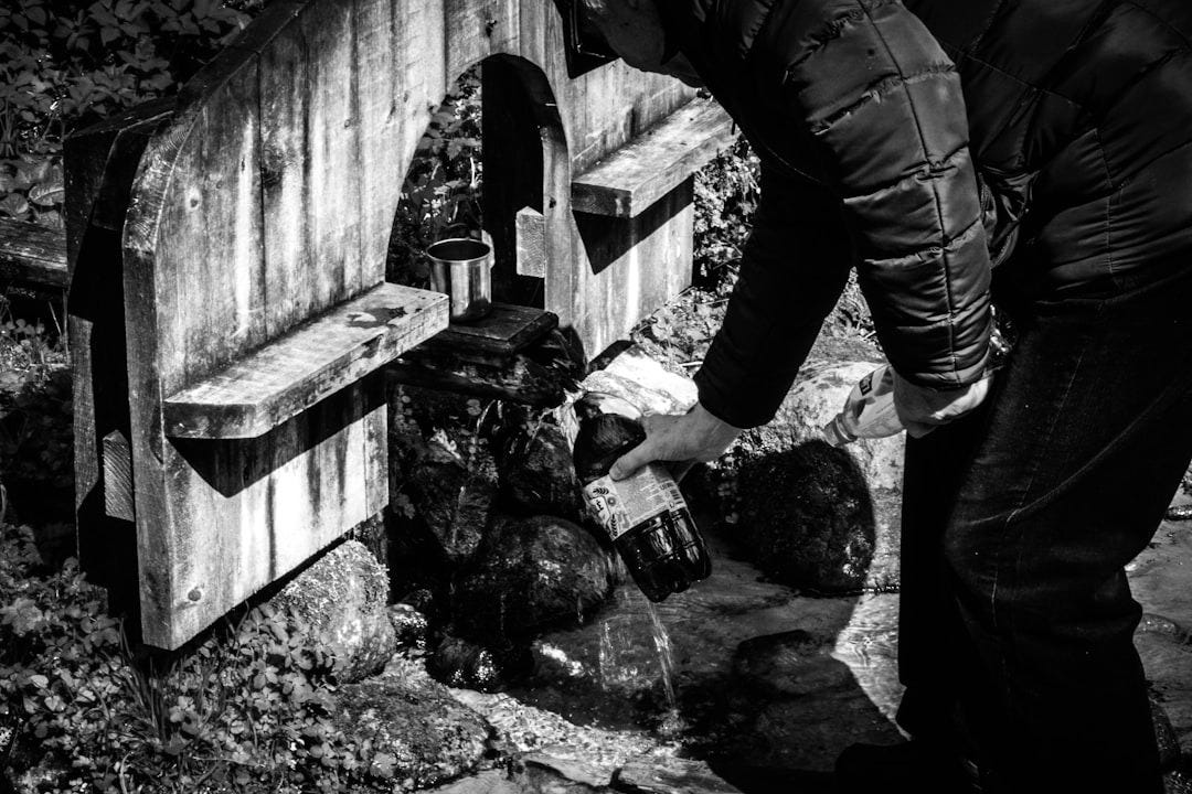 a person pouring water into a small stream