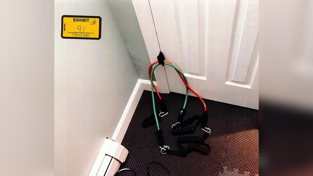 A red pair and green pair of exercise bands was attached to a door. A red pair and green pair of exercise bands was attached to a door.
