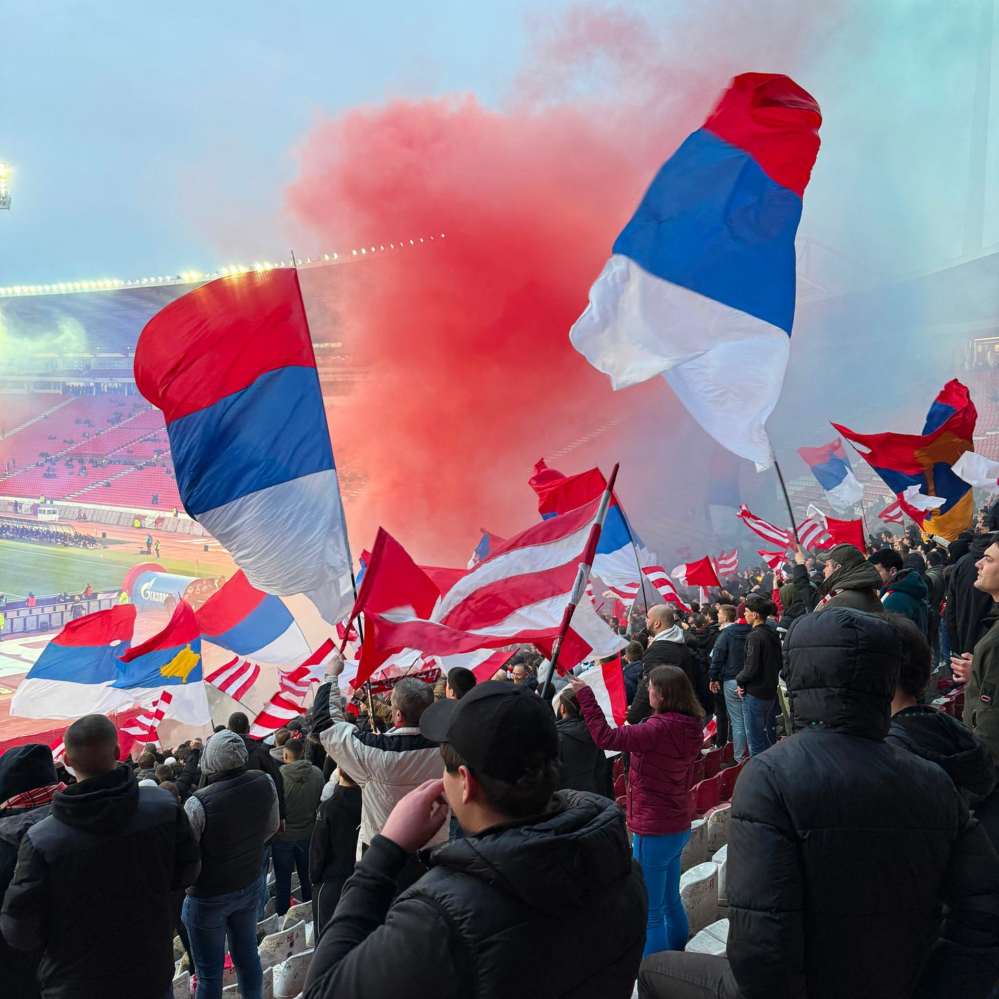 Colored smoke rises from the front of the Ultra’s section. Flags wave beneath it.
