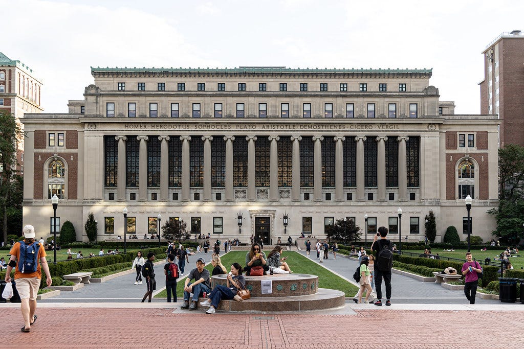 students walking and lounging outside Butler Library, which has pillars across the front and names engraved on the facade students walking and lounging outside Butler Library, which has pillars across the front and names engraved on the facade