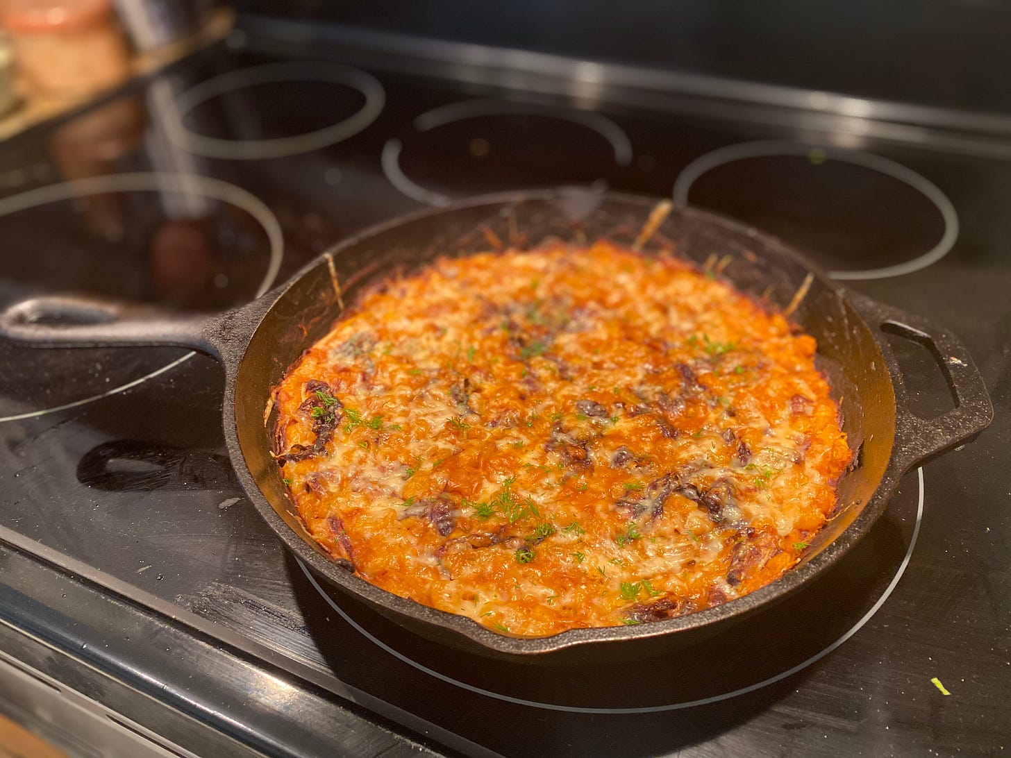 A cast-iron pan of the beans with radicchio and cheese, described above. Dill is sprinkled over the top.