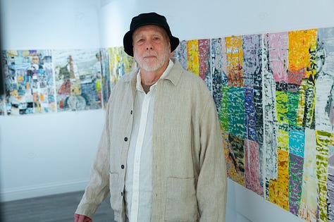 Artist and paintings in exhibition
