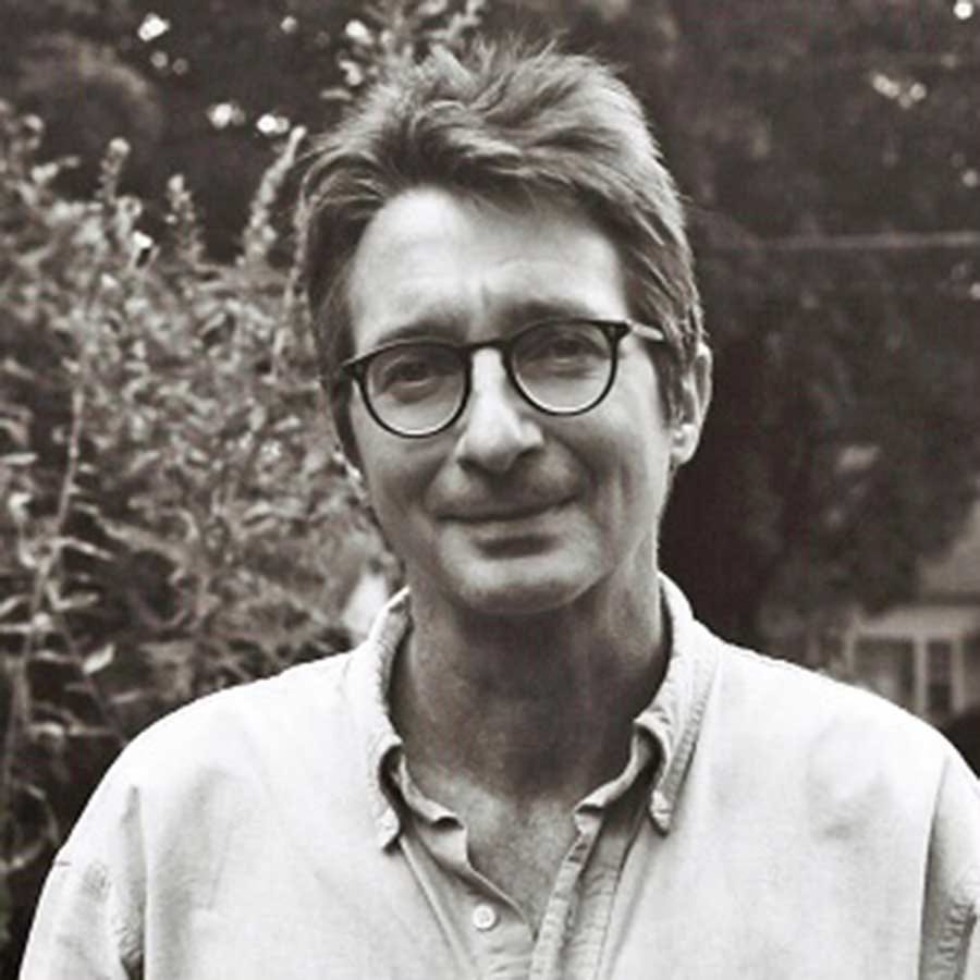 Black and white photo of Dean Young in an open-necked shirt and glasses.