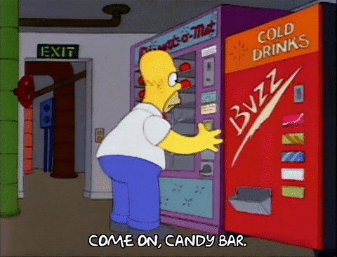 Homer Simpson presses buttons on a vending machine, hoping for a candy bar.