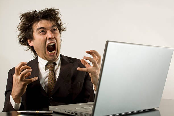 Man screaming in front of his computer