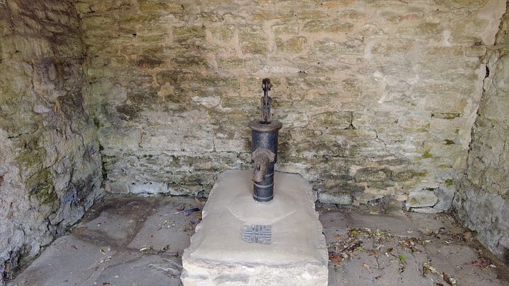 A bus shelter built of stone which inside hides an old village pump. Bath Road, Atworth, Wiltshire. Image: Roland's Travels
