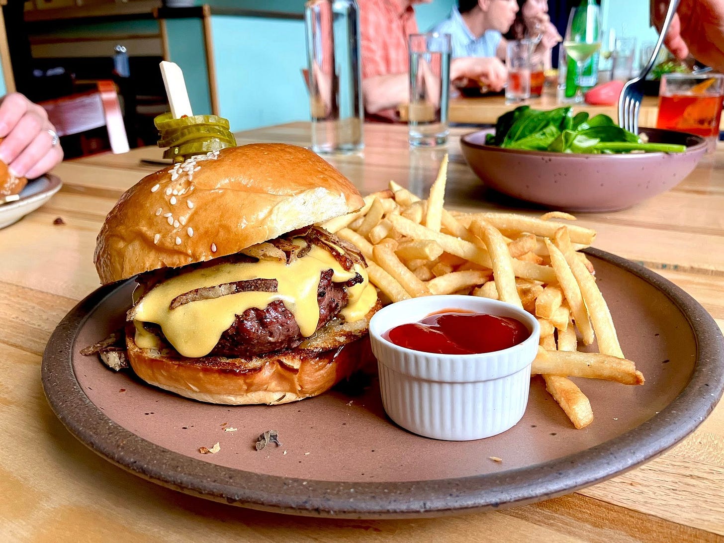 May be an image of 2 people and burger