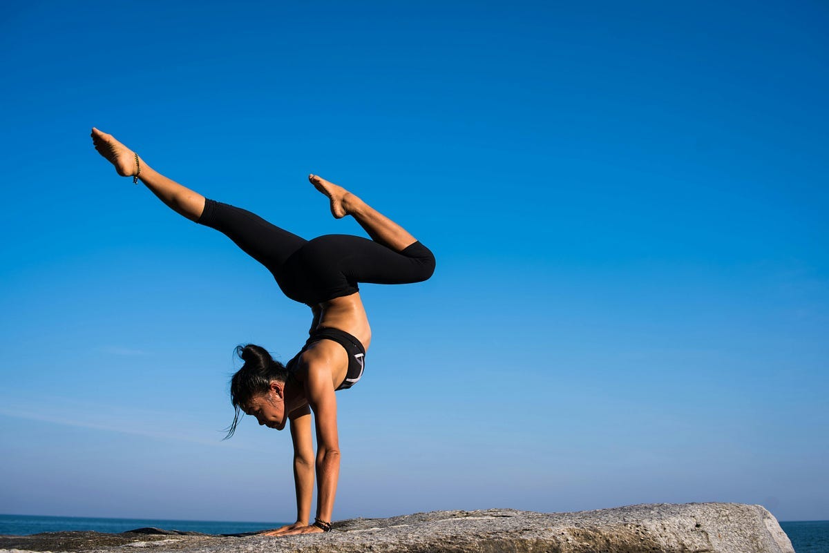Woman balancing on rock cliff