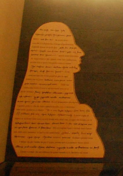 Silhouette of a woman's head and torso containing writing; museum display