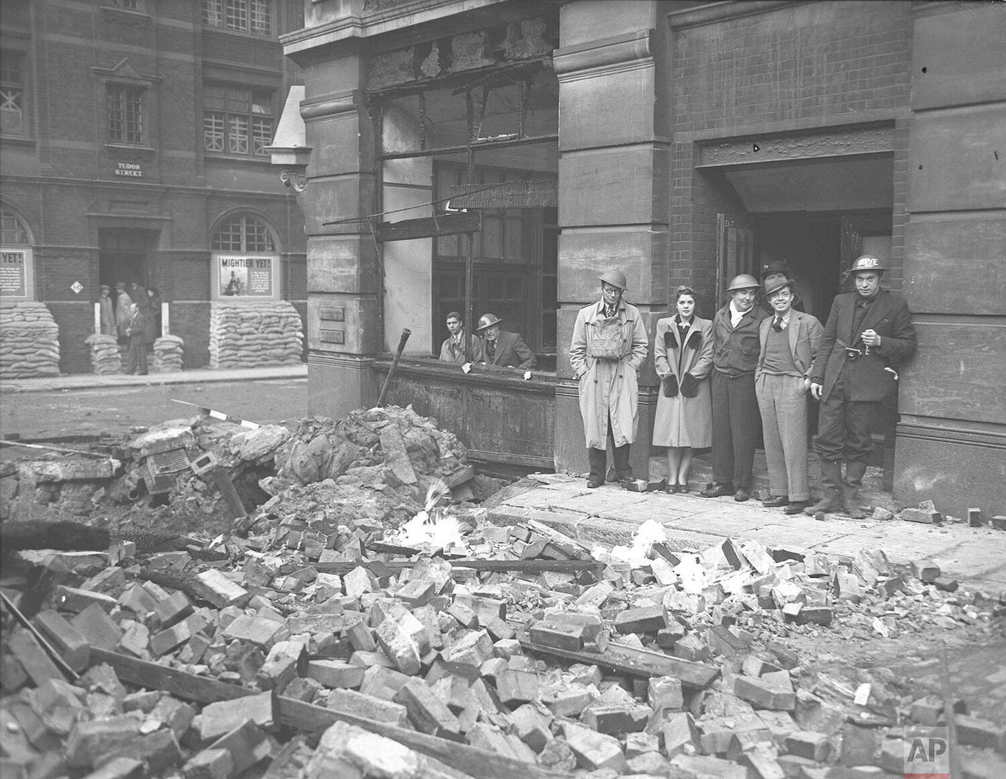 Piles of rubble line a British street, smoke still rising from the debris after a devastating German air raid. Amidst the destruction, resilient residents and civil defense personnel stand firm, embodying the unwavering spirit of the nation during the Blitz. Piles of rubble line a British street, smoke still rising from the debris after a devastating German air raid. Amidst the destruction, resilient residents and civil defense personnel stand firm, embodying the unwavering spirit of the nation during the Blitz.